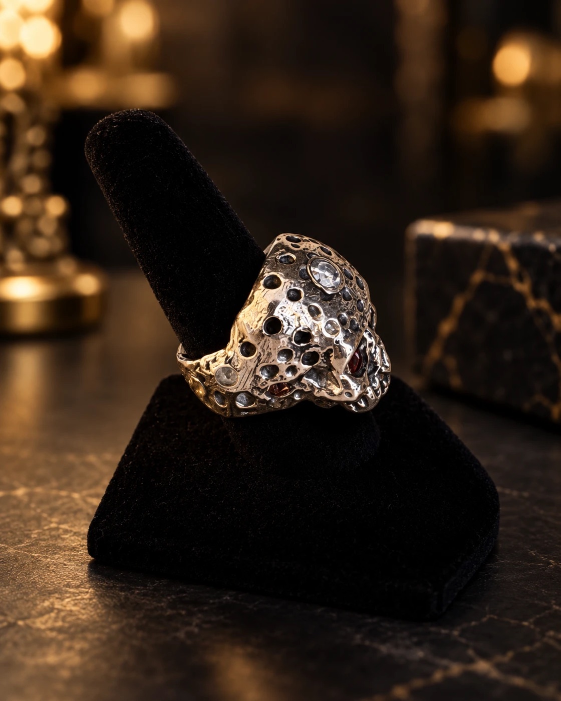 Side view of the skull ring showing the pitted, cratered texture wrapping around the band